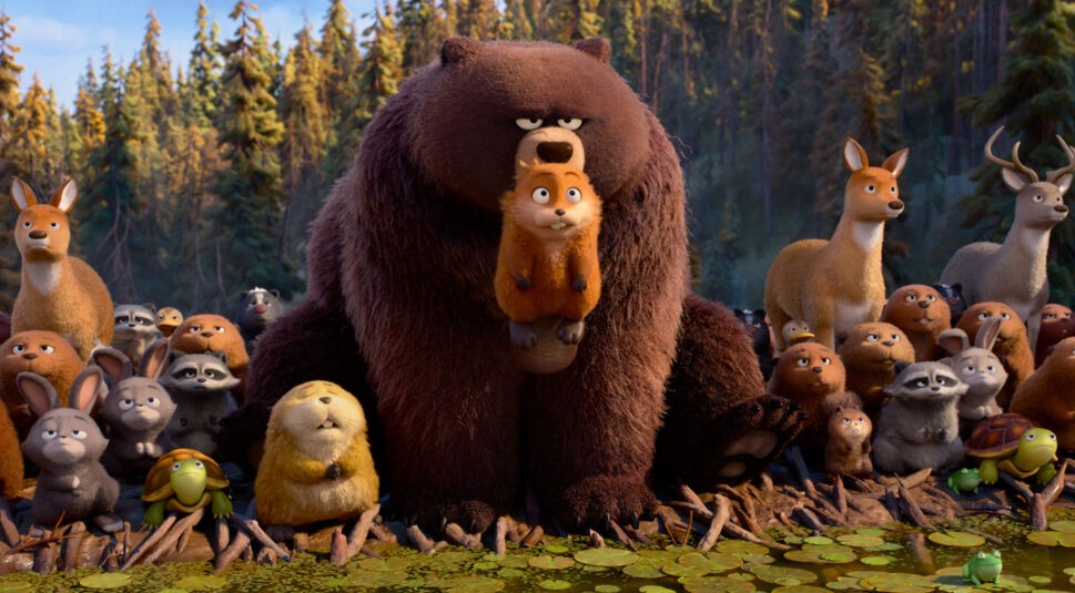 Gruppenbild sehr vieler Waldbewohner. Im Mittelpunkt steht ein Bär, der den Hauptcharakter (ein Biber) vorsichtig im Maul hält.