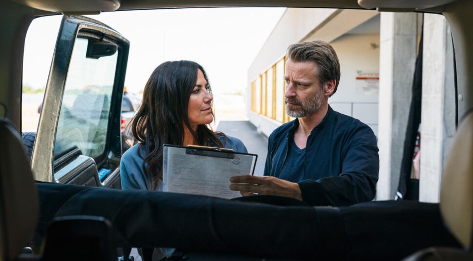 Dr. med. Vet. Maja Freydank (Bettina Zimmermann) und Dr. med. Vet. Sebastian Pfeifer (Max von Pufendorf) stehen vor einer.geöffneten Autotür. Er hält eine List in der Hand, die beiden sprechen miteinander.