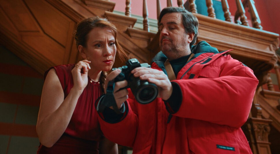 Auf dem Bild in dem Artikel zum Ende von "Fabian und Die mörderische Hochzeit" erklärt, ist der Hauptdarsteller mit einem weiteren Charakter zu sehen. Beide schauen auf eine Kamera.