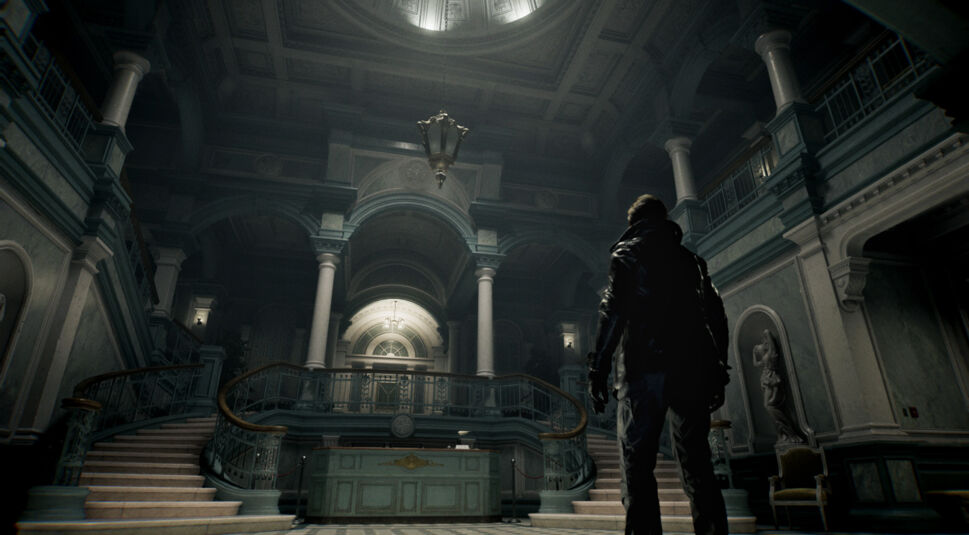 Auf dem Bild aus dem Resident Evil Requiem Test ist Leon S. Kennedy in einer düsteren, prunkvollen Eingangshalle zu sehen. Er steht im Vordergrund mit dem Rücken zur Kamera und blickt auf eine monumentale Treppe mit Säulen und Galerie. Das Licht fällt dramatisch von oben herab und erzeugt eine bedrohliche, gespannte Atmosphäre, die die unheimliche Stimmung der Szene unterstreicht.