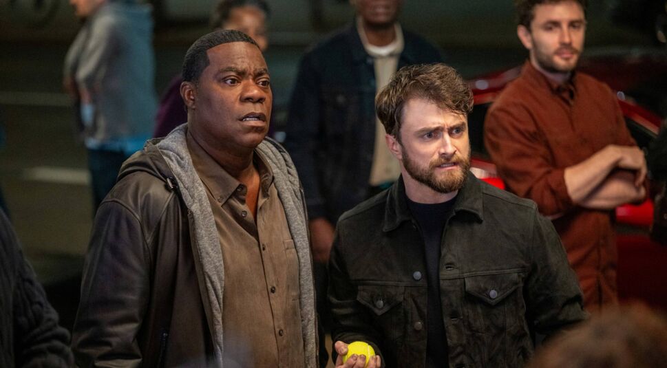Auf dem Bild in den GigaTV-Highlights im April 2026 siehst Du eine Szene aus „The Fall and Rise of Reggie Dinkins“ mit Reggie Dinkins, gespielt von Tracy Morgan, und Arthur Tobin, dargestellt von Daniel Radcliffe. Beide schauen angespannt nach vorne, während Reggie einen ernsten Ausdruck hat und Arthur eine gelbe Kugel hält, was die dramatische Stimmung unterstreicht.