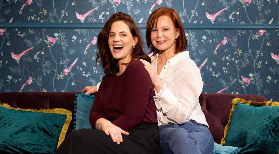Auf dem Bild zur "Unter uns"-Besetzung sind die Schauspielerinnen Marie Zielcke und Petra Blossey zu sehen, die gemeinsam auf einem Sofa sitzen.