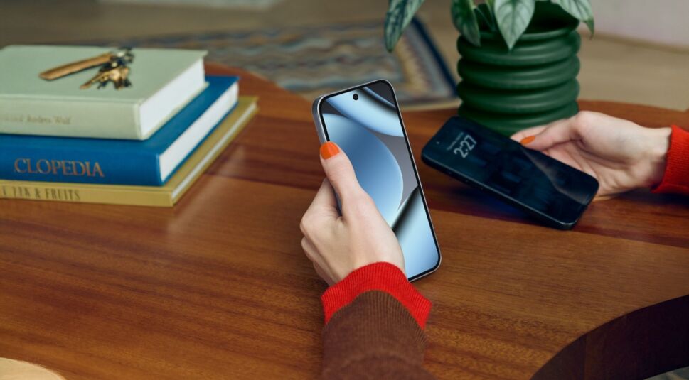 Frau sitzt am Tisch mit Pixel 10 Pro in der Hand.