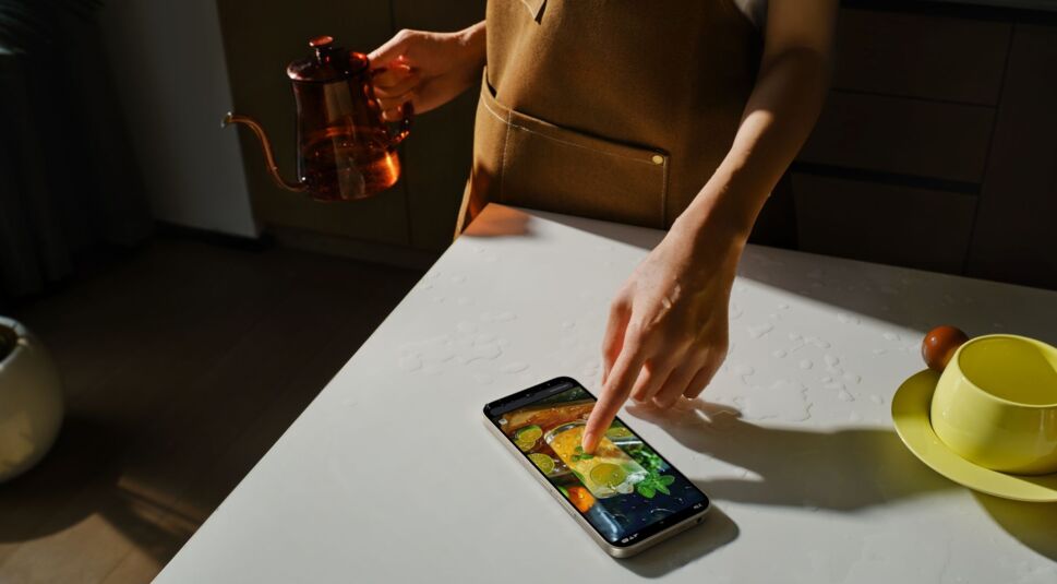 Blick auf junge Frau, die auf das nasse Display des Redmi 17 5G tippt.