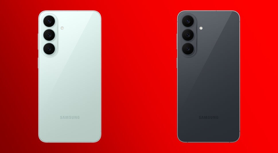 Auf dem Bild zum Samsung Galaxy S26 FE liegt der Fokus auf den Farbvarianten Pistachio und Graphite, jeweils mit Blick auf die Rückseite. Links ist das Gerät in zartem Mintgrün mit vertikal angeordneter Triple-Kamera zu sehen, rechts die dunkelgraue Graphite-Variante im selben Kameradesign. Beide Rückseiten glänzen dezent, wirken hochwertig und edel und stehen im auffälligen Kontrast zum roten Hintergrund.