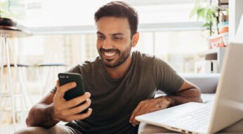 Mann setzt sein Android-Smartphone zurück und lächelt