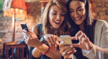 Fröhliche Frauen mit iPhone