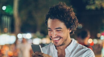 Junger Mann stellt an seinem Smartphone eine App wieder her.