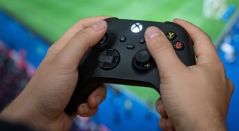 Jemand hält den Controller der Xbox Series X/S.