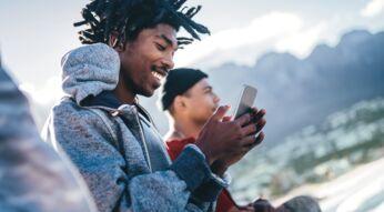 Boy-outside-texting-and-smiling_1920