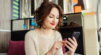 Junge Frau spielt Survival-Game auf ihrem Smartphone.