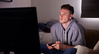 Junger Mann spielt Hellblade auf einer Konsole