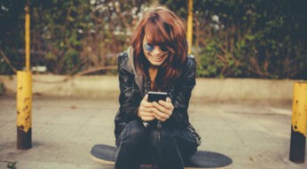 Junge Frau verwendet Twitter am Smartphone.