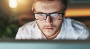 Junger Mann arbeitet am Windows-10-PC.