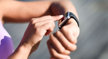 Frau tippt auf das Display ihrer Smartwatch.