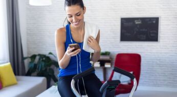 Frau nutzt Samsung Health am Handy, während sie Sport macht.