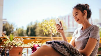 Junge Frau spielt am Smartphone ein entspannendes Spiel.