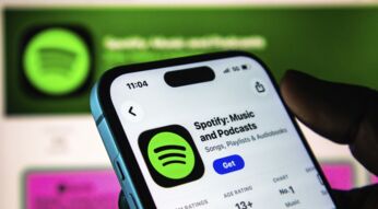 Nahaufnahme einer Hand, die ein iPhone hält, auf dem die App-Store-Seite von Spotify zu sehen ist.