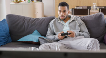 Junger Mann spielt Days Gone auf der PlayStation 4