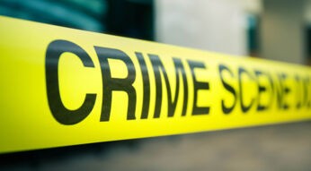 Gelbes Absperrband mit der Aufschrift „Crime Scene Do Not Cross”.