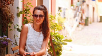 Junge Frau hält ihr Smartphone in der Hand, das einen Passwort-Manager installiert hat.