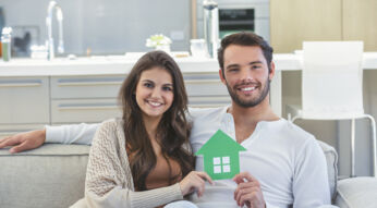 Paar hält kleines Haus in der Hand