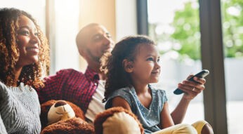 Eltern und kleines Mädchen auf Sofa