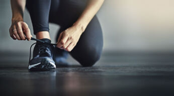 Frau bindet ihren Sportschuh zu - Neue Puma-AR-Sneaker stehen per App in Flammen