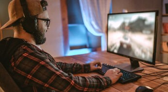 Junger Mann sitzt an PC und testet Gaming-Tipps