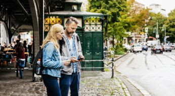 Paar sucht Ziel im Urlaub per Smartphone - Digitale Reiseführer als App