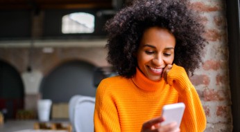 Junge Frau erhält am Smartphone eine WhatsApp-Benachrichtigung.