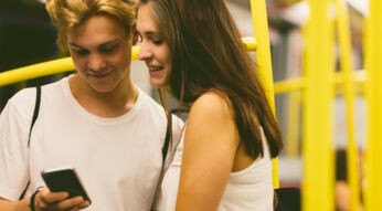 Zwei junge Menschen spielen am Smartphone