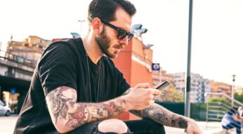 Junger Mann plant am Smartphone eine Nachricht mit Telegram.