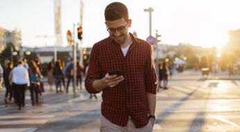 Mann schaltet am Android-11-Smartphone den Dark Mode ein.