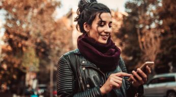 Frau schaltet den Dark Mode von WhatsApp am Smartphone ein.