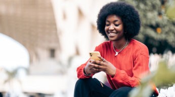 Frau mit Smartphone nutzt eSIM-Push