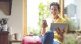 Frau nutzt WhatsApp auf Smartphone und Tablet.