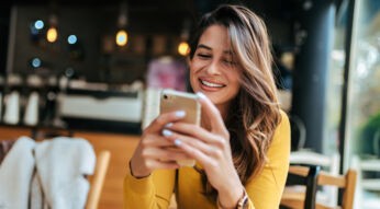 Frau lachend mit Smartphone