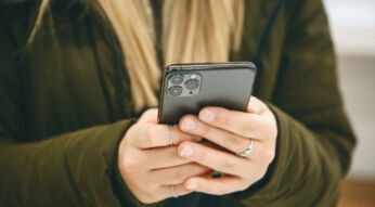 Frau hält ein iPhone in den Händen.