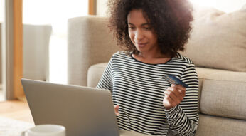 Frau überweist am Laptop Geld auf ihr PayPal-Konto