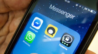 Hand hält Smartphone mit Threema-Symbol