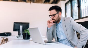 Man grübelt vor seinem Laptop