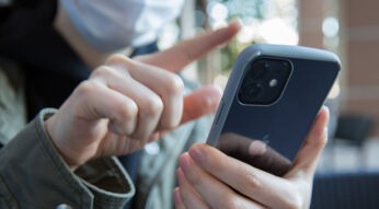 Frau wischt mit Finger auf iPhone 12