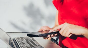 Frau tippt auf ihr iPhone.