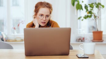 Frau schaut etwas ratlos auf ihren Laptop