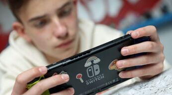 Junger Mann zockt Spiel an der Nintendo Switch.