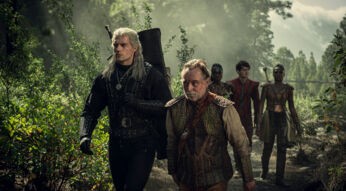 Hexer Geralt (Henry Cavill) streift mit Barde Rittersporn (Joey Batey) durch einen Wald.