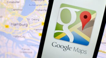 Google-Maps-App auf einem Smartphone neben einer Karte