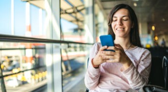 Frau nutzt ihr Smartphone unterwegs