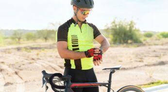 Fahrradfahrer schaut auf seine Smartwatch.